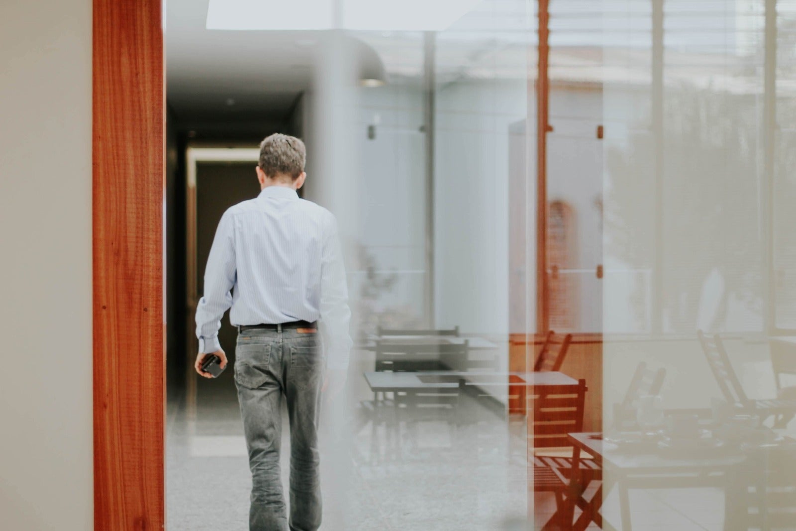 A man walking away from a glass door in an office