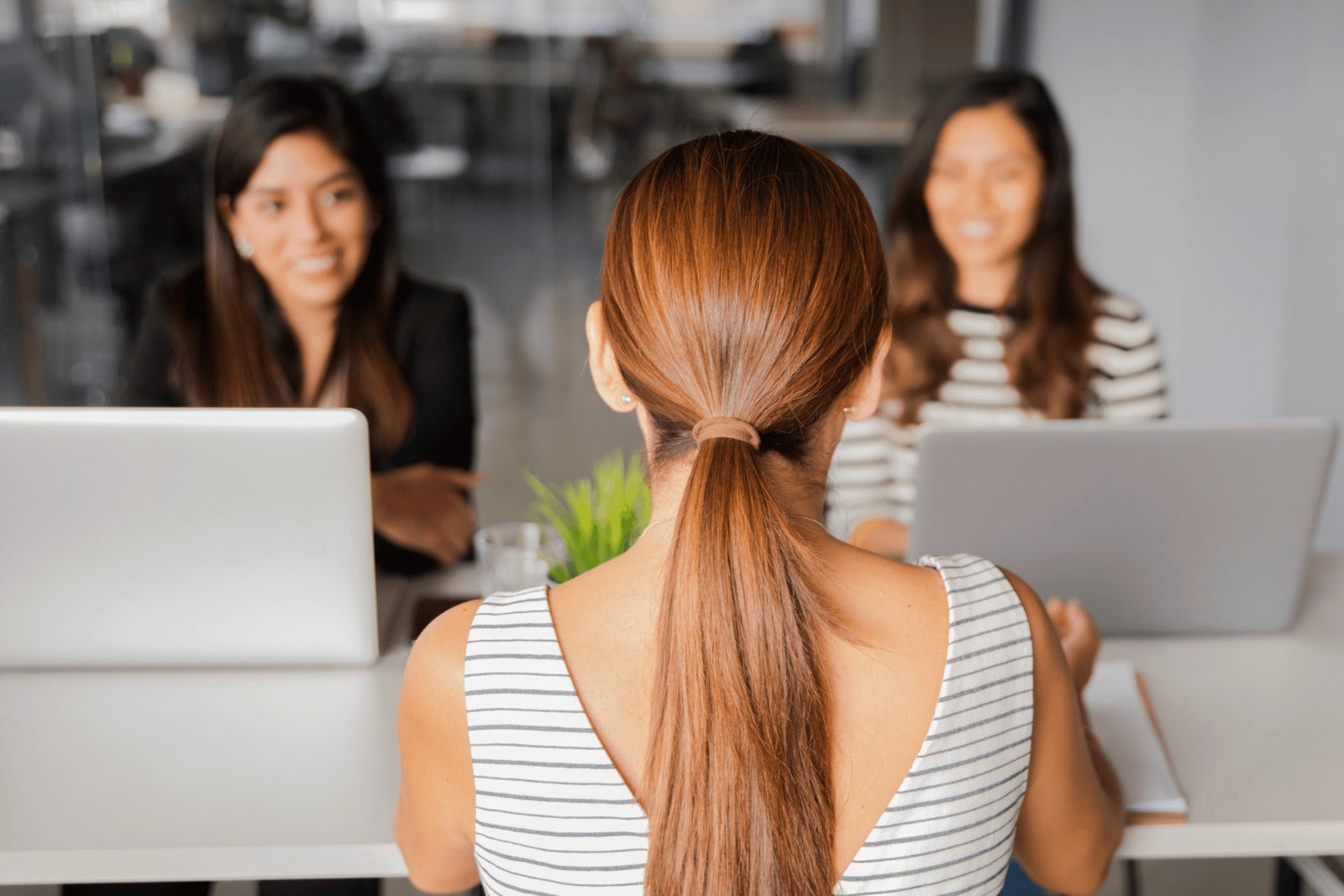two interview panelists speak with job candidate in conference room